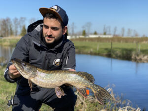 Lusi Mendez hält kleinen Hecht am Fluss in die Kamera